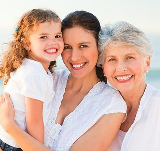 Three generations of related women smiling (grandmother, mother, daughter) 