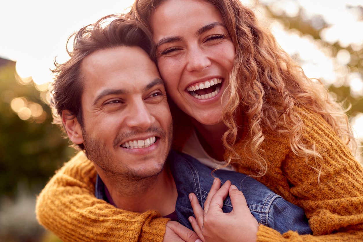 Portrait Of Happy Loving Couple With Man Giving Woman Piggyback